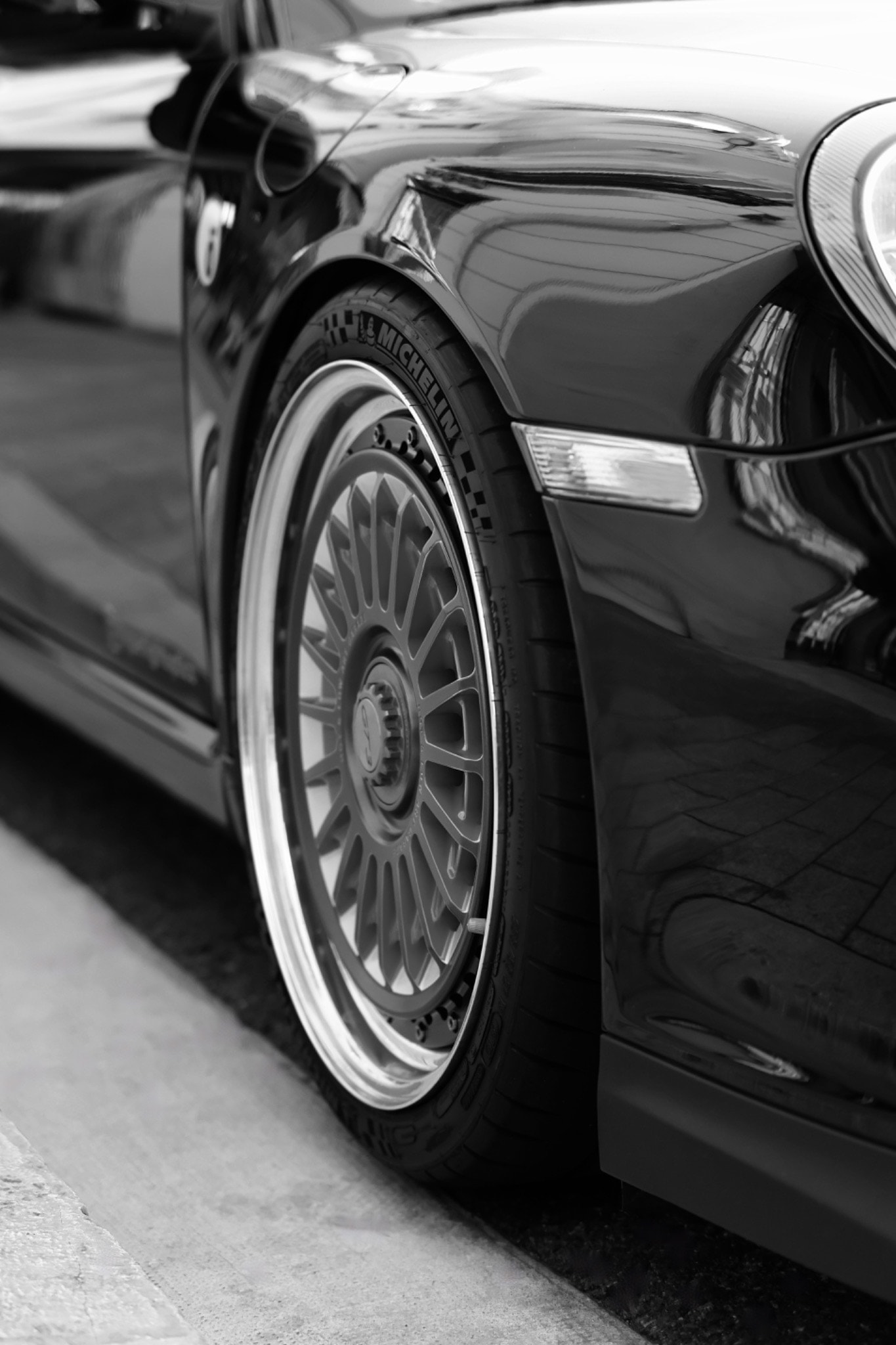 Détail de la jante et de la carrosserie brillante d'une Porsche noire