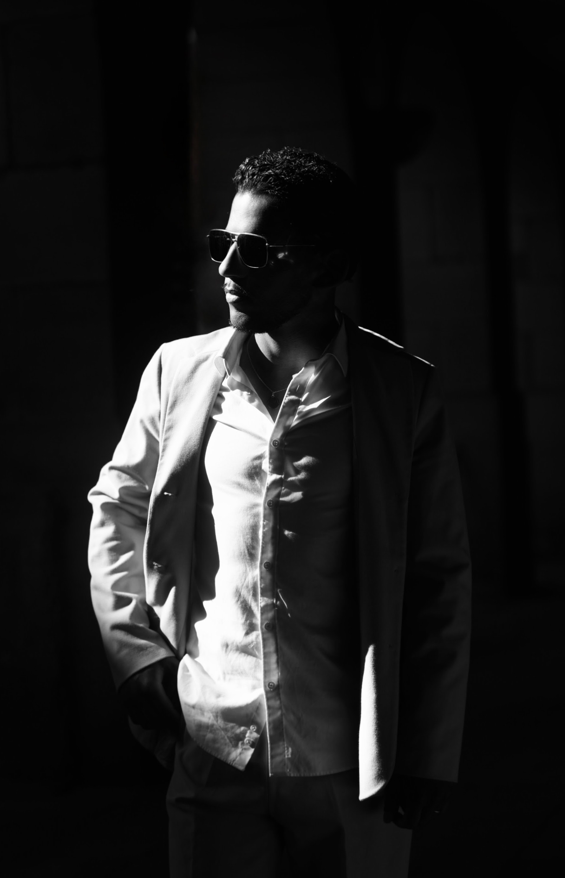 Homme en veste claire photographié en clair-obscur