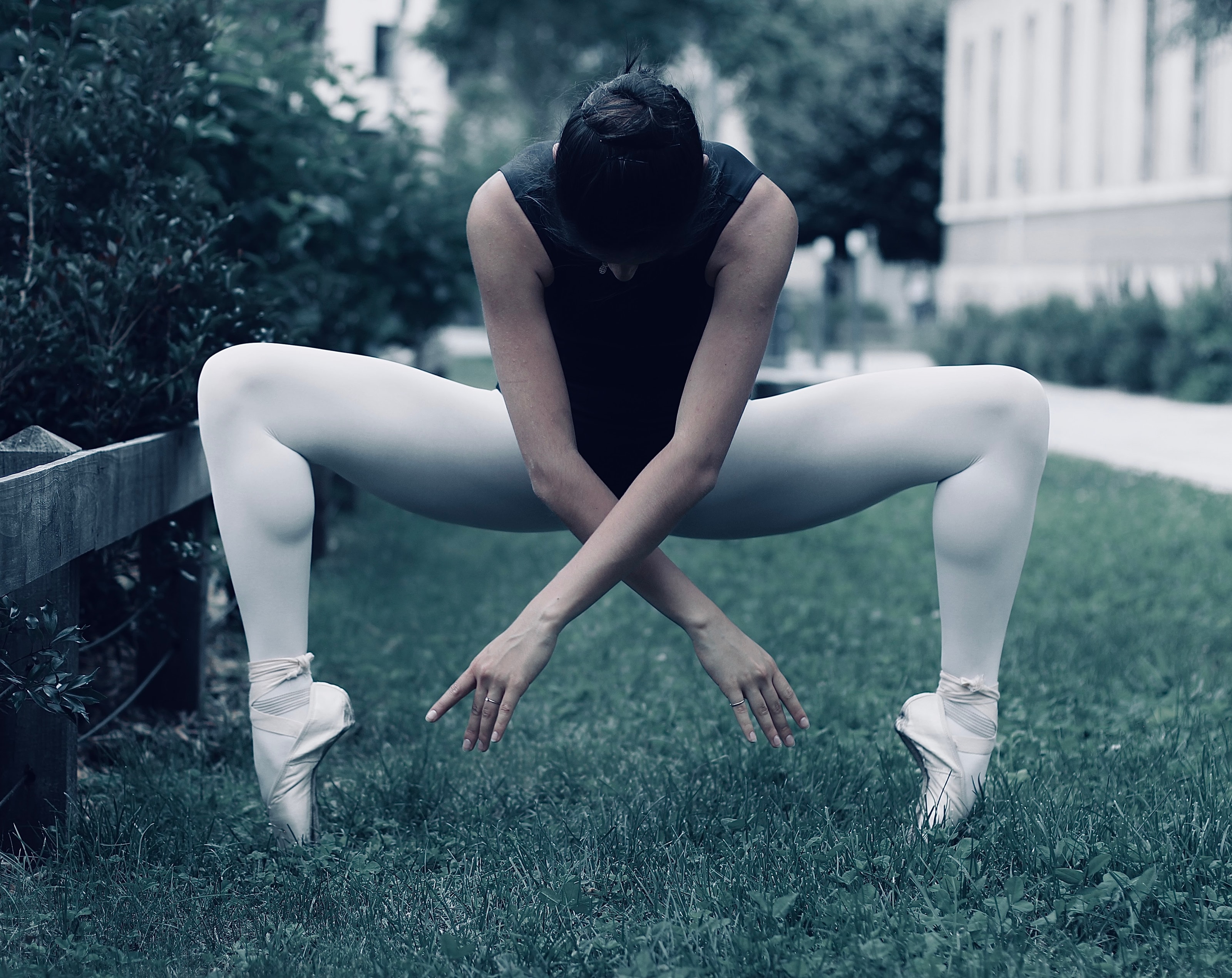 Danseuse en position ouverte sur une pelouse, chapeau noir