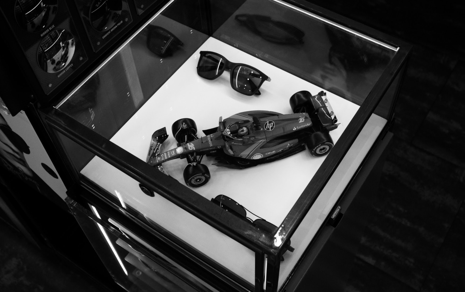 Vitrine avec lunettes de soleil et modèle réduit de Formule 1