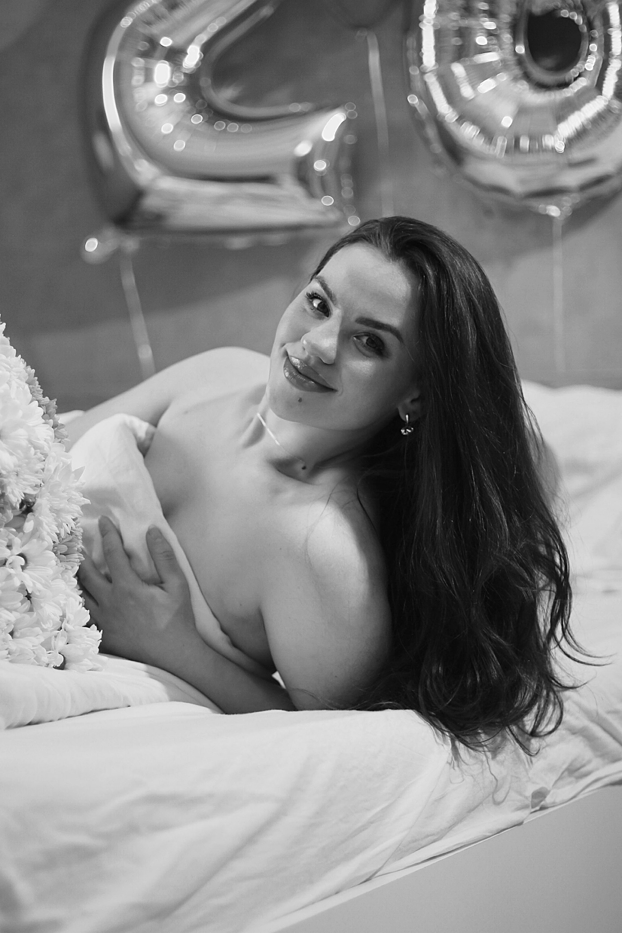 Portrait en noir et blanc d'une femme allongée sur un lit